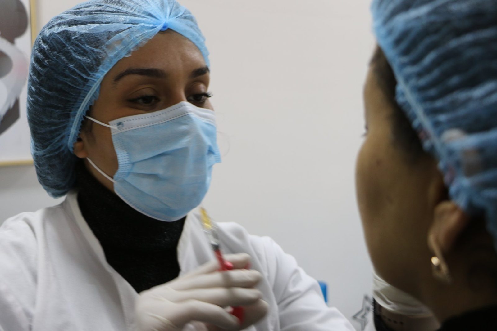 Injection réalisée avec masque, gants et charlotte